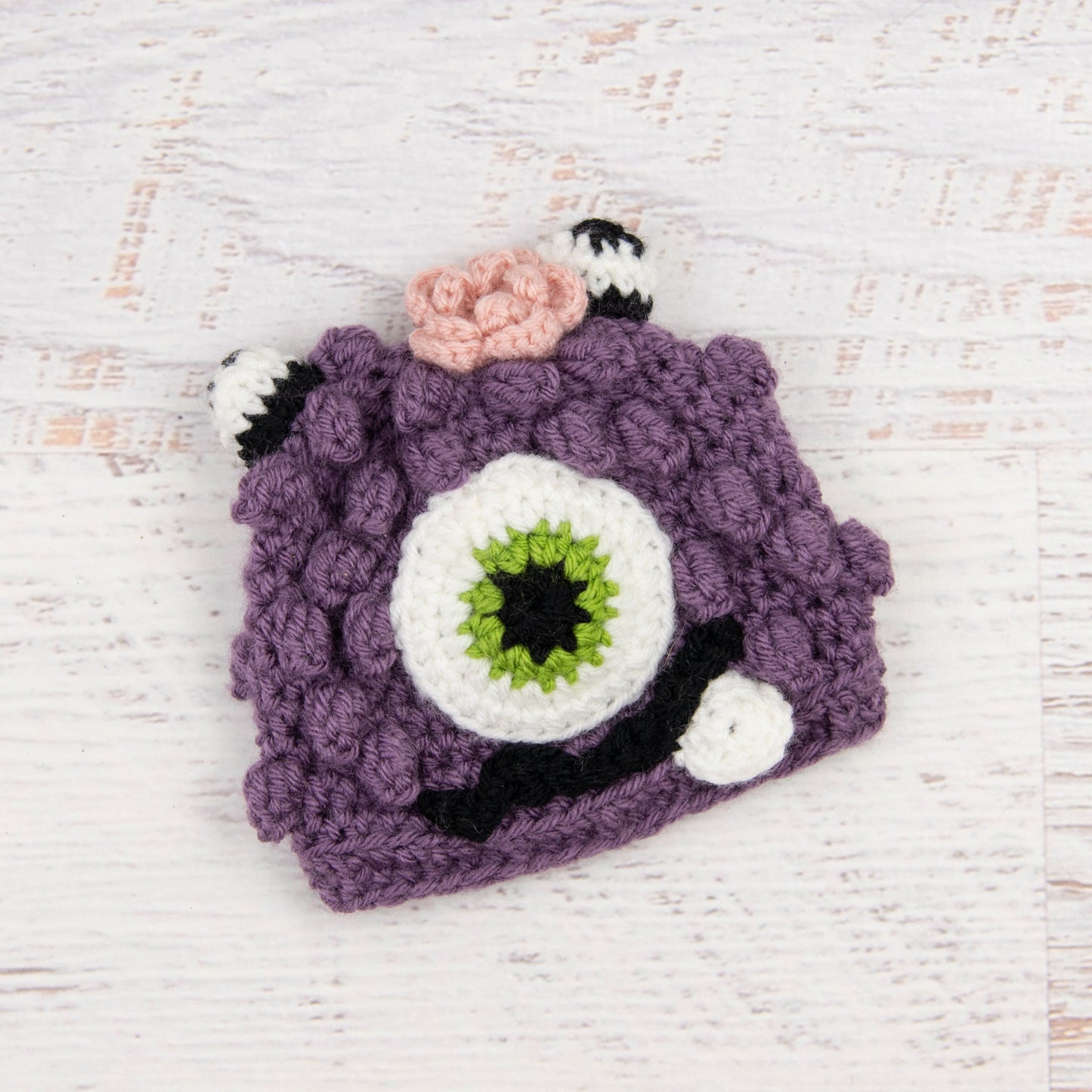 In-Stock 0-6 Month Little Monster in Dusty Purple with Fern Eye and Pink Flower.